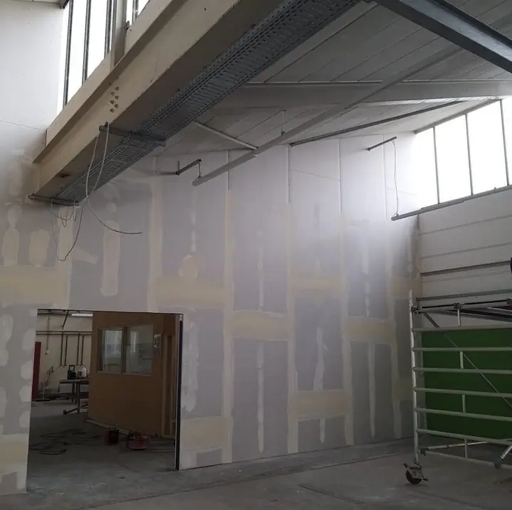 Verspachtelte Trockenbauwand in einer Werkhalle unter einer Galerie mit Stahlträgern