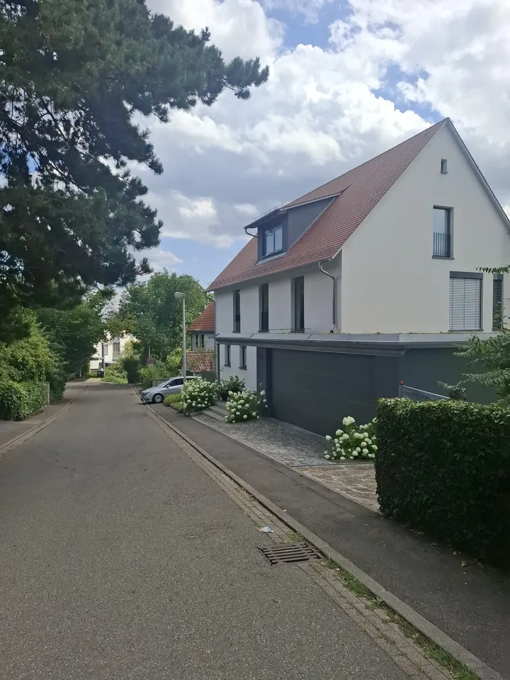 Gedämmtes Einfamilienhaus mit fertig verputzter Fassade und rotem Ziegeldach