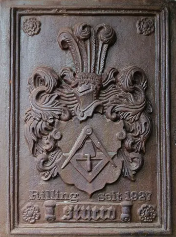 Gusseiserne Wappentafel mit Kelle und Zirkel und der Inschrift Rilling seit 1927