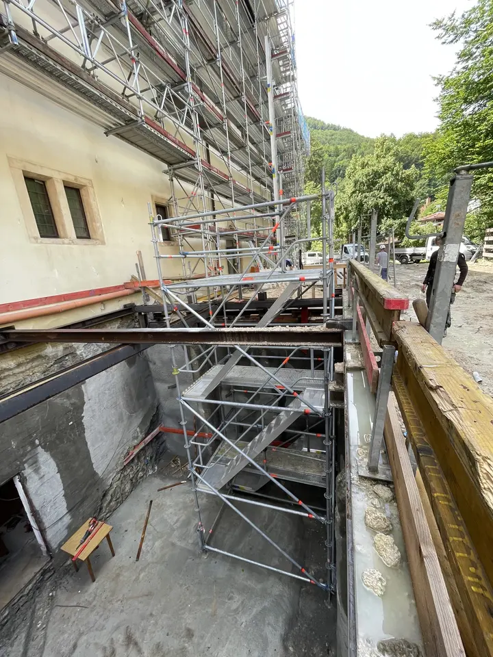 Traggerüst in einem Kellergraben zur Abstützung der Arbeitsebene an einem historischen Gebäude