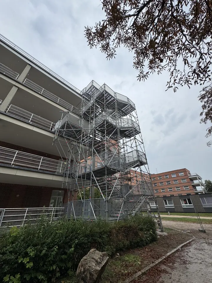 Gerüsttreppenturm als Baustellenzugang an einem Wohngebäude mit Laubengängen