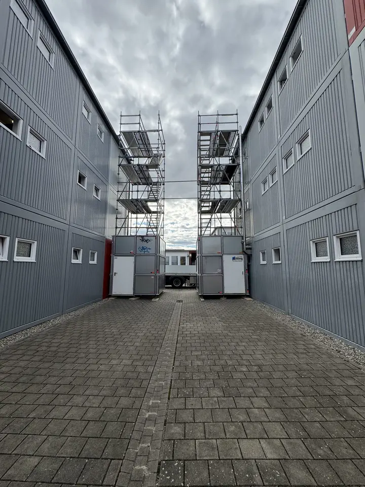 Arbeitsgerüst im schmalen Hof zwischen zwei Hallengebäuden