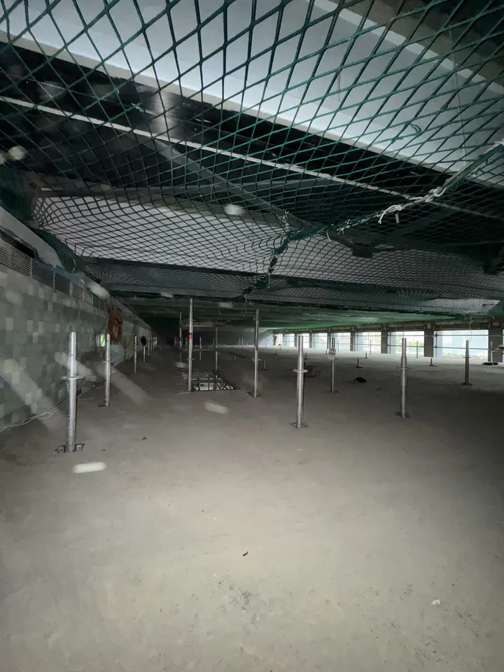 Personenauffangnetz unter der Decke eines leeren Rohbaugeschosses