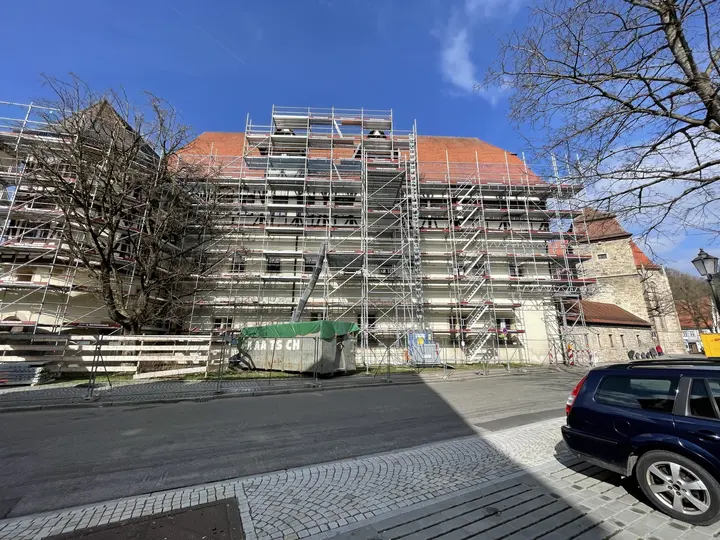Historisches Gebäude mit rotem Ziegeldach vollflächig eingerüstet